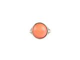 Gros plan sur une bague contenant une pierre orange