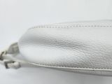 a close up of a white purse on a white surface