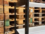 a white bathtub sitting in front of a stack of wooden pallets