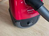 a red vacuum that is sitting on a wooden floor