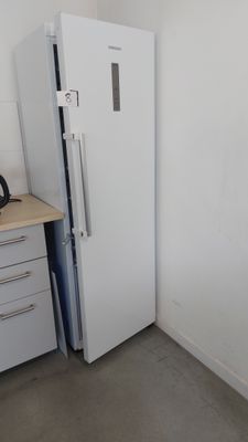 un réfrigérateur blanc dans le coin d'une cuisine