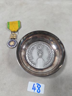 Valeur et discipline : une coupelle en métal argenté et une …