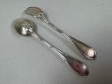 two spoons and a fork sitting on a table