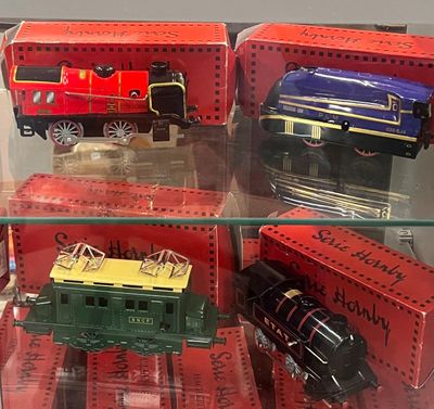 quatre trains miniatures exposés dans une vitrine