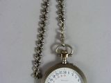 une montre de poche en argent avec une chaîne autour d'elle