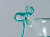 a glass vase with a blue flower on top of it