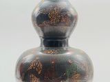 a black vase with a design on it on a white background