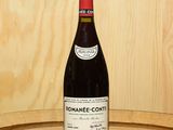 a bottle of wine sitting on top of a wooden barrel
