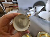 a person holding a cup and saucer on a table