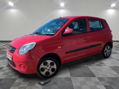 the small red car is parked in a room with a checkered floor