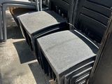 many chairs that are sitting on the side of the street