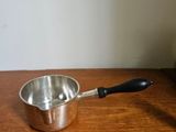 a small saucepan sitting on a wooden table next to a blender