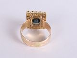 a gold ring with a black stone in it