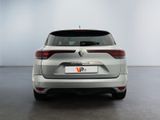 the rear end of a silver car in a white room