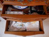 une commode en bois dont un tiroir est rempli d'objets