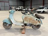 an old scooter that is sitting in a garage