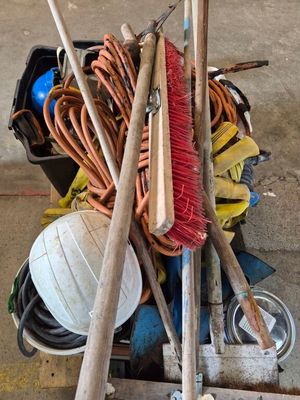 un tas de balais et d'autres outils posés sur une charrette