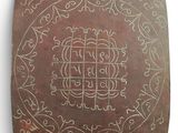 a metal plaque with a design on it on a wall