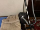 a vacuum that is sitting on the floor next to a bed