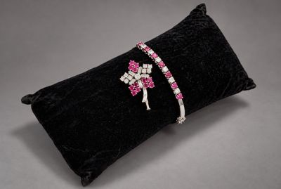 a black pillow with pink and white crystals on it