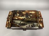 an old wooden box with a painting on it sitting on a table