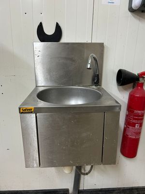 un extincteur à côté d'un lavabo et un extincteur