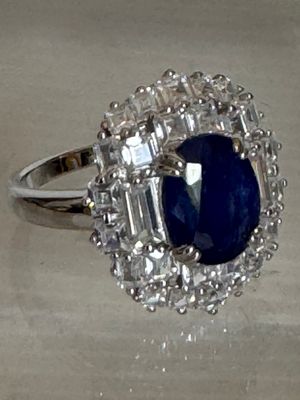 une image d'une bague avec une pierre bleue entourée de diamants