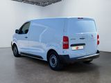 the back of a white van is parked in a large room