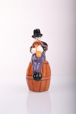 a figurine of a man sitting on top of a barrel