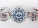 three blue and white plates sitting on top of a white surface