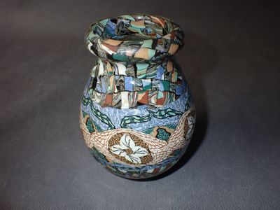 a small vase with a colorful design on it on a table