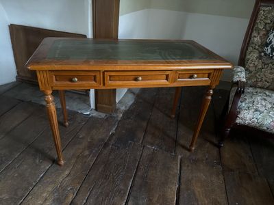 a wooden desk with two drawers and a chair in the corner