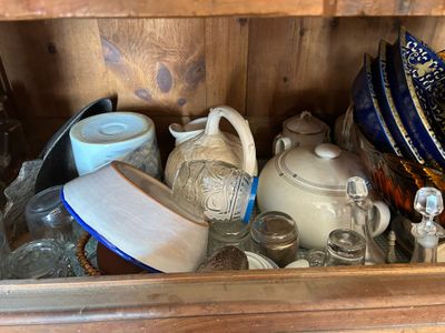a wooden cabinet filled with dishes and cups