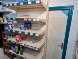 many shelves in the corner of a store that have various items on them