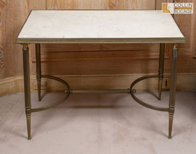 une petite table avec un plateau en marbre posée sur un sol recouvert de moquette