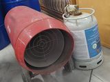 a man sitting on a couch next to a stack of barrels