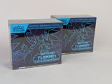 deux boîtes de figurines Pokémon posées sur une surface blanche