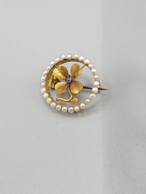 un gros plan d'une broche ornée de perles et d'une fleur