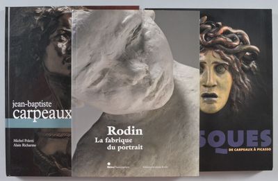 deux livres posés sur une table, à côté d'une statue représentant une femme