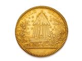 gros plan d'une pièce d'or sur une surface blanche