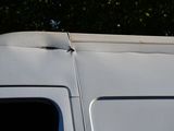 a white van that is parked in a lot with trees in the background