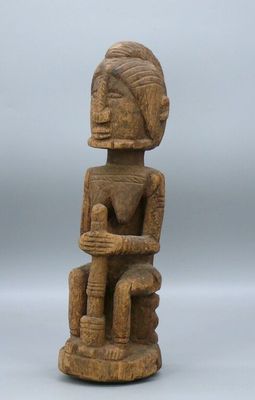 a wooden statue of a person sitting on a chair