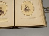 an old photo of a couple of men sitting on top of a book