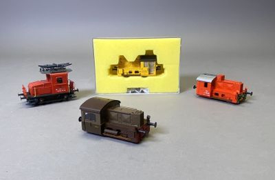 trois trains miniatures assis l'un à côté de l'autre sur une table