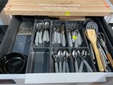 un tiroir rempli d'ustensiles et de cuillères dans une cuisine