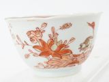 a white bowl with a red and orange floral design on it