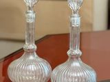 pair of clear glass candlesticks sitting on top of a red table