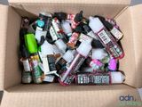 une boîte en carton remplie d'un assortiment de peintures et de colles