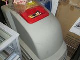a trash can sitting on top of a trash can in a garage