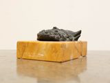 a small statue of a cat on a marble block